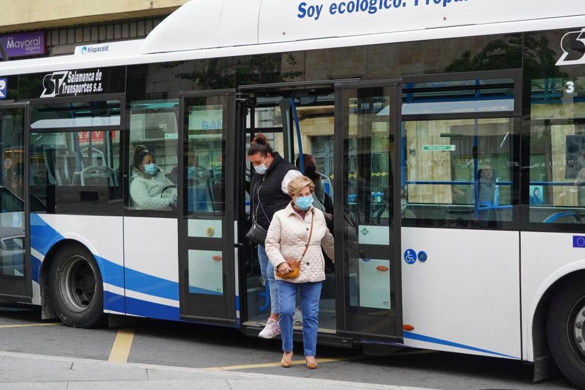 Dos usuarias de transporte urbano se bajan de un autobús.