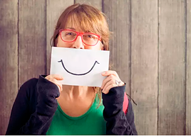 Mujer con una sonrisa pintada en un papel.