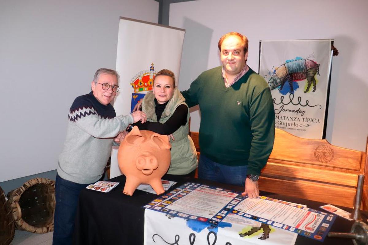 Jesús Merino, Sandra Méndez y Roberto Martín con el cerdo que recogerá los fondos de las degustaciones.