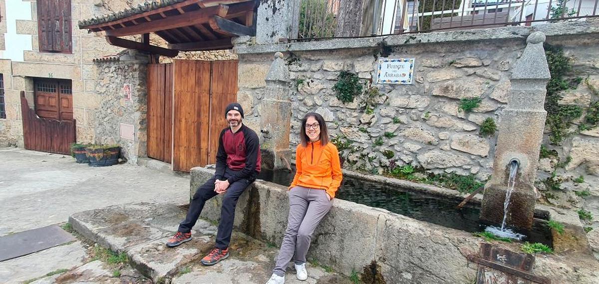 Javier y Angela Bermejo posan en la Fuente del Arrabal de Candelario tras su regreso a su pueblo para emprender una nueva etapa laboral. TEL