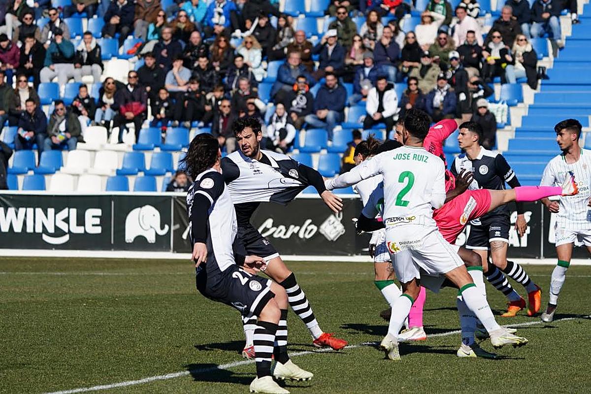 Carlos de la Nava es agarrado dentro del área por un jugador del Córdoba en el Reina Sofía.