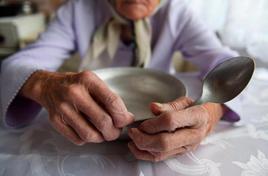 Una persona de avanzada edad con un plato vacío.