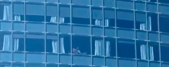 La pareja copulando en la ventana del hotel.