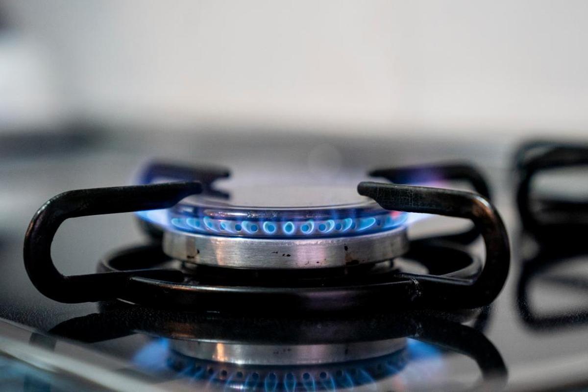 Una persona enciende un fuego de una cocina de gas.