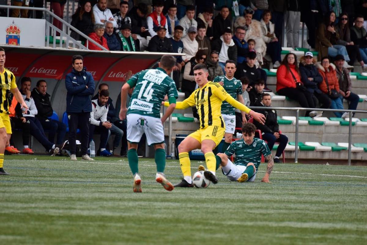 Acción del partido en la que los jugadores del Guijuelo intentan frenar al jugador visitante