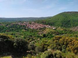 Vista del casco urbano y el entorno natural de San Esteban de la Sierra desde un tramo de la ruta