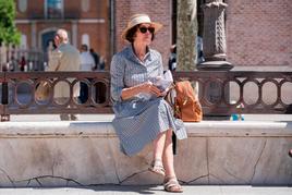 Una mujer se protege del sol con un sombrero