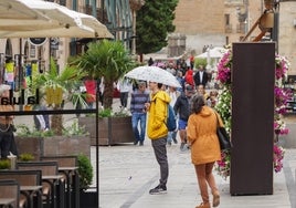 Un joven se cubre con un paraguas en Salamanca.