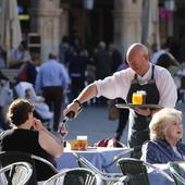 Un camarero sirve un vino en una terraza de la Plaza Mayor de Salamanca