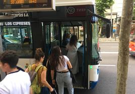 Usuarios a punto de coger el autobús en la avenida de Mirat.