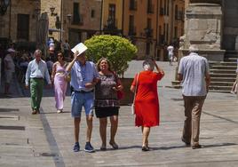 Viandantes pasean por el centro de Salamanca a pleno sol.