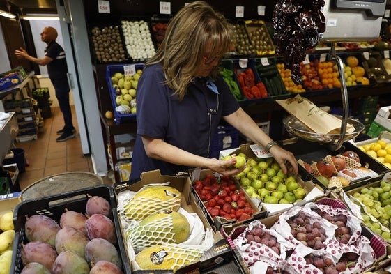 Una frutera del Mercado coloca higos en una caja.