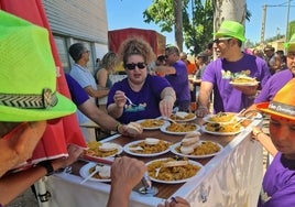 Una de las peñas, transportando sus platos de paella