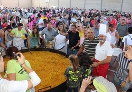 Momento del reparto del arroz, con numerosos voluntarios para agilizarlo