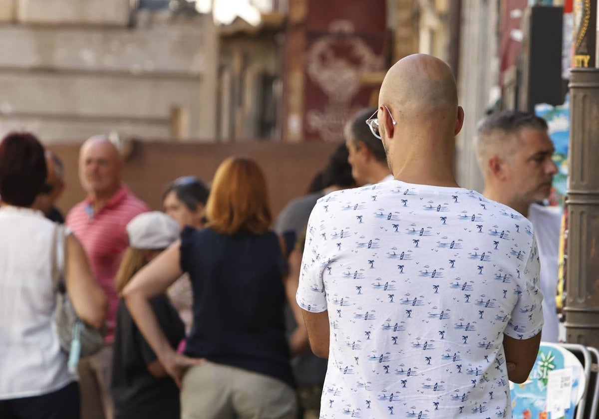 Una persona que sufre calvicie pasea por el centro de Salamanca.