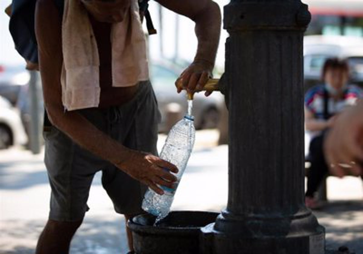 Un hombre intenta refrescarse.