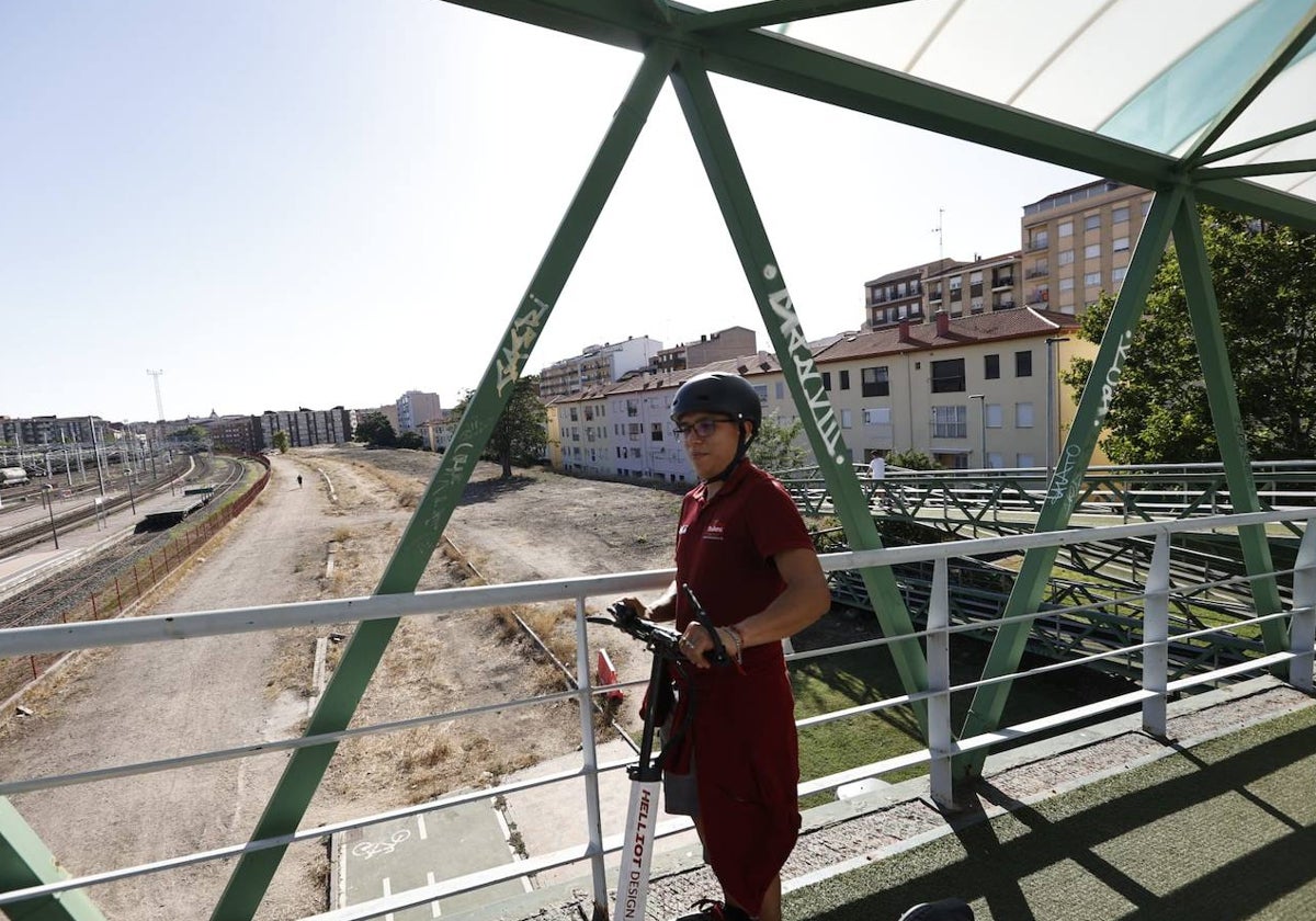 Una mujer cruza la pasarela de Vialia, sobre los terrenos en los que se proyectan huertos urbanos.