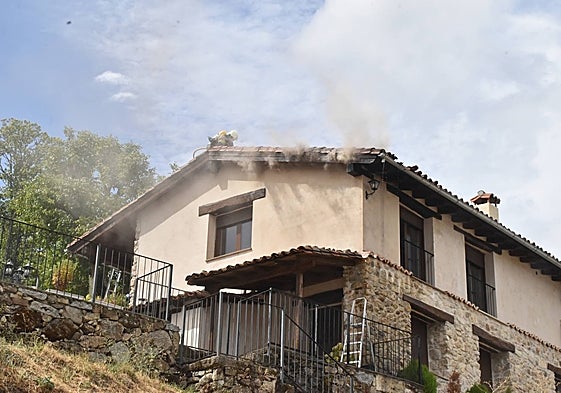 Un bombero intenta sofocar el incendio en la vivienda de Candelario.