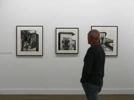 Un hombre se interesa por la exposición fotográfica «Señas de identidad».