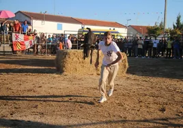 Uno de los mozos escapa de una de las vaquillas saltarinas en la capea de Santiz