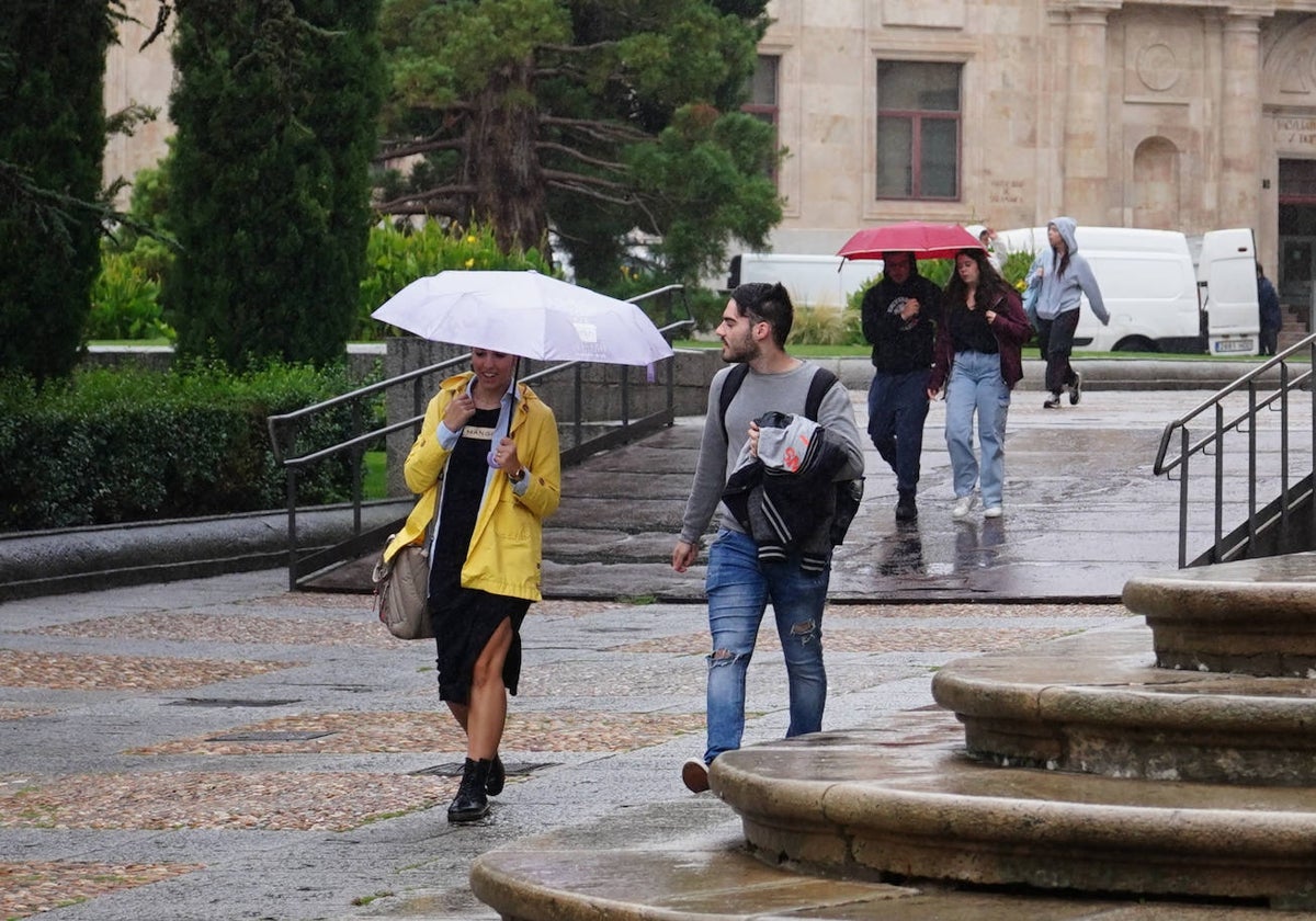 Jóvenes protegiéndose de la lluvia en la plaza de Anaya.