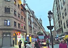 Los bomberos asegurando una antena, en la calle Zamora.