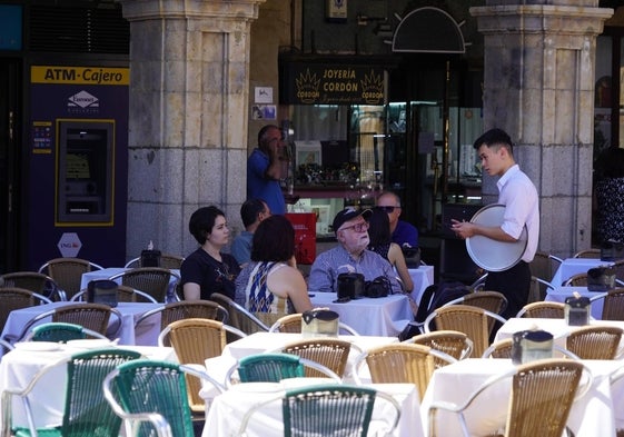 Un camarero atendiendo una terraza de la Plaza Mayor.