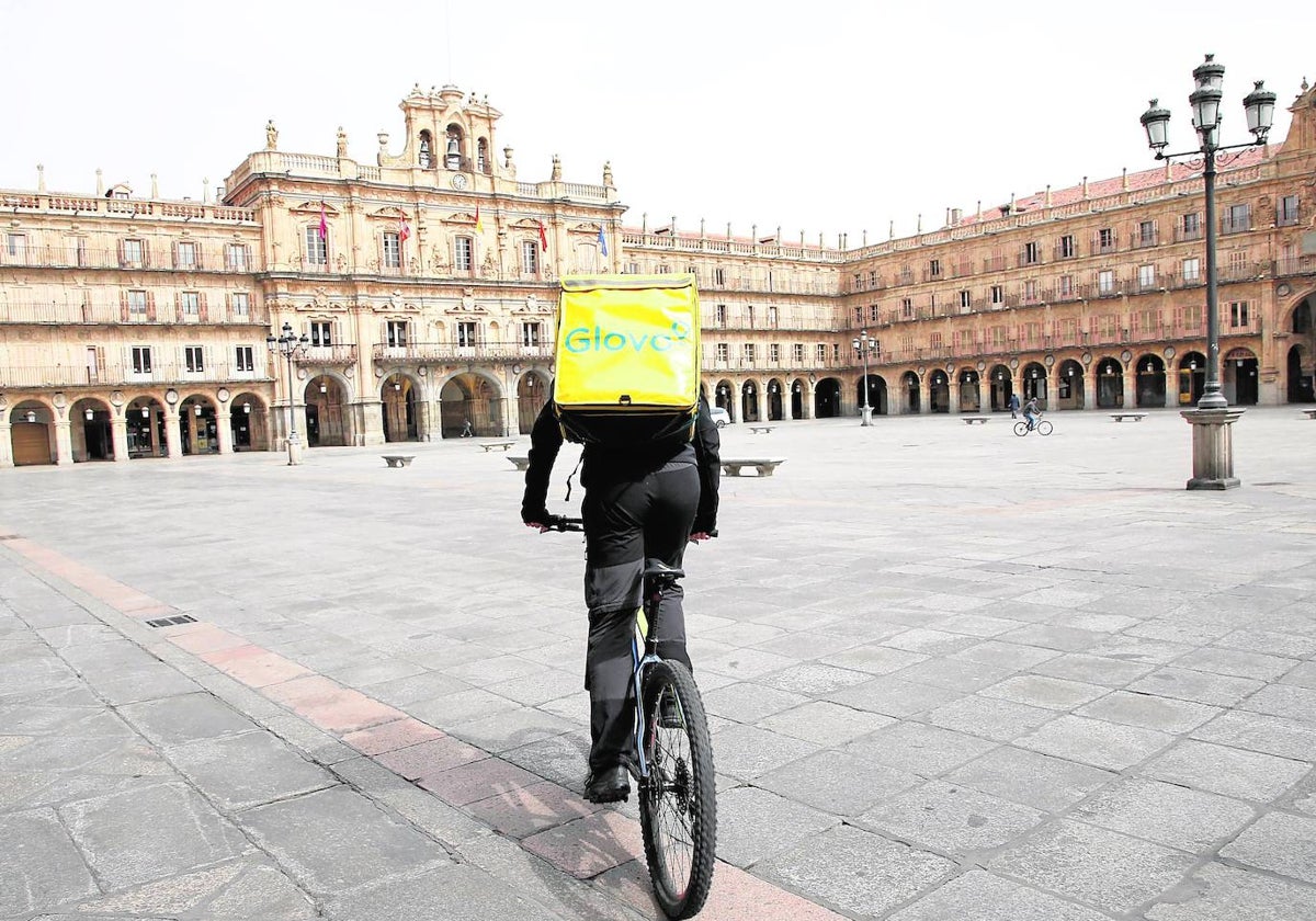 Un repartidor circula en bicicleta por la Plaza Mayor.