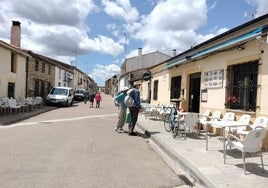 Dos peregrinos observan el cartel de un establecimiento hostelero en Fuenterroble de Salvatierra.