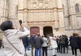 Turistas, abrigados, a las puertas de la fachada de la Universidad.