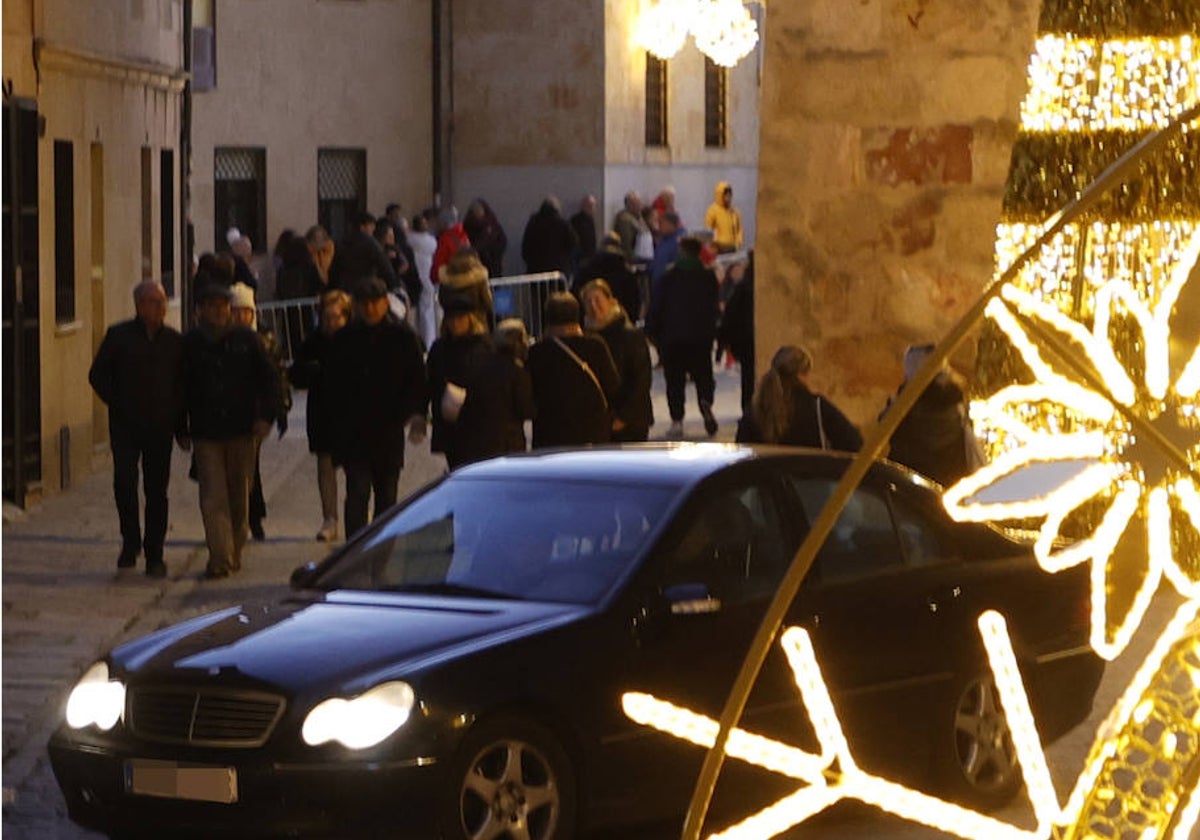 Un vehículo circula este miércoles entre público en la calle San Vicente Ferrer.