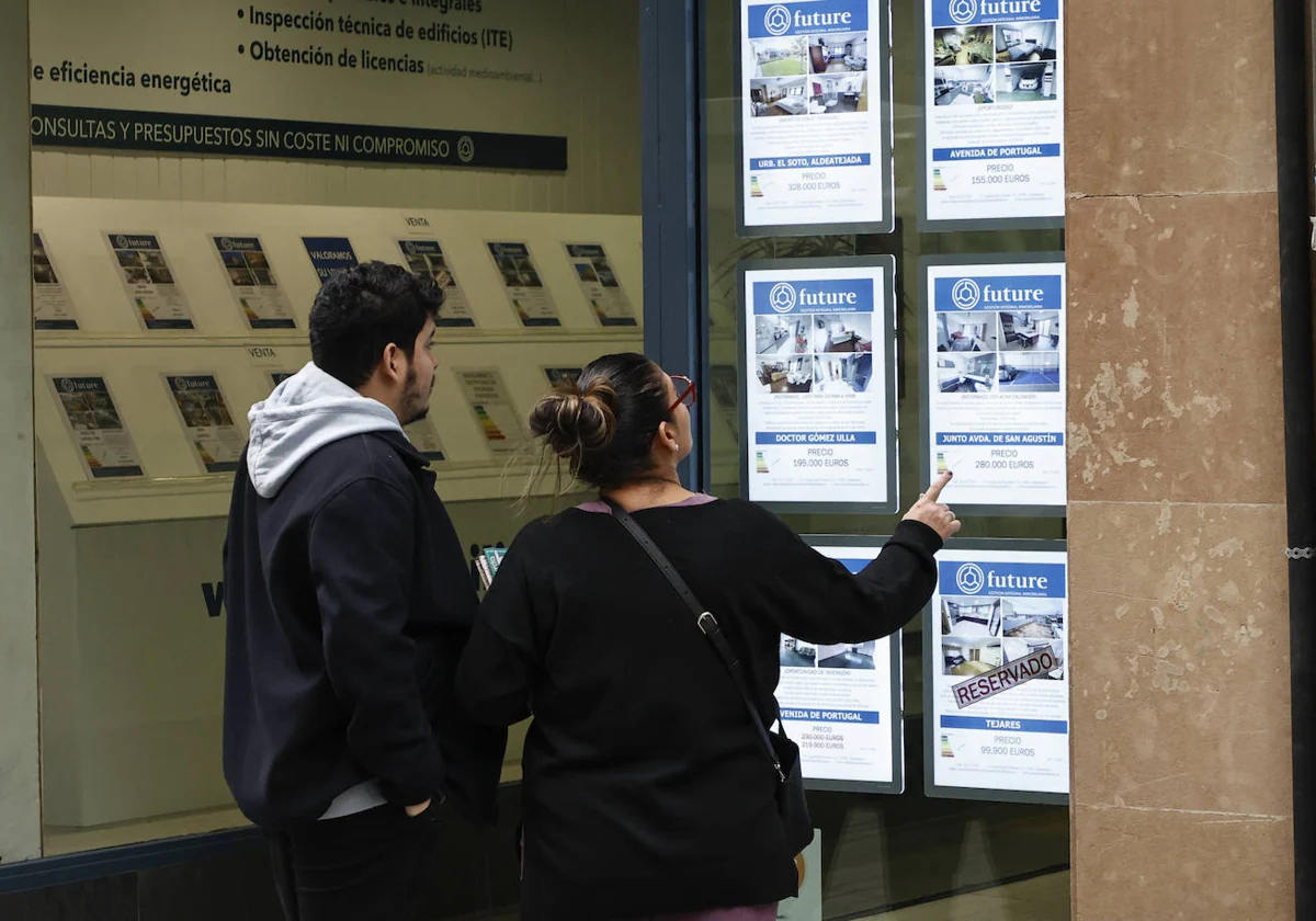 Una pareja mirando las ofertas de una inmobiliaria.