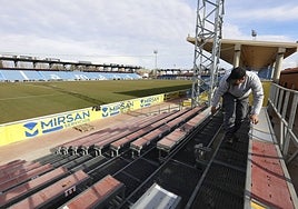 Un operarios colocando la grada supletoria en el Reina