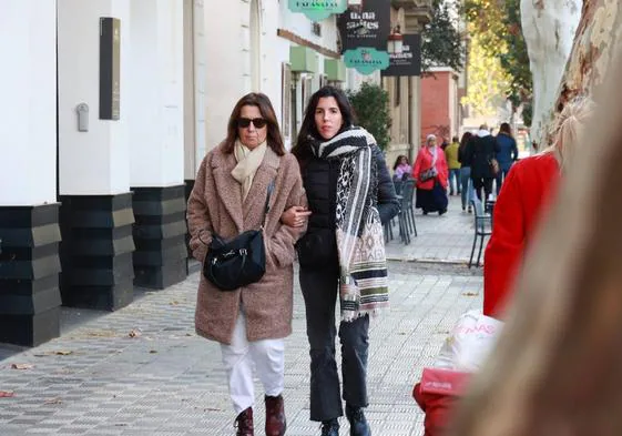 Dos mujeres paseando con muchos frío por la calle.