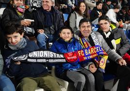 Aficionados posan con una bufanda del partido.