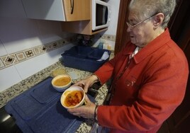 Humildad abre los recipientes en su cocina.