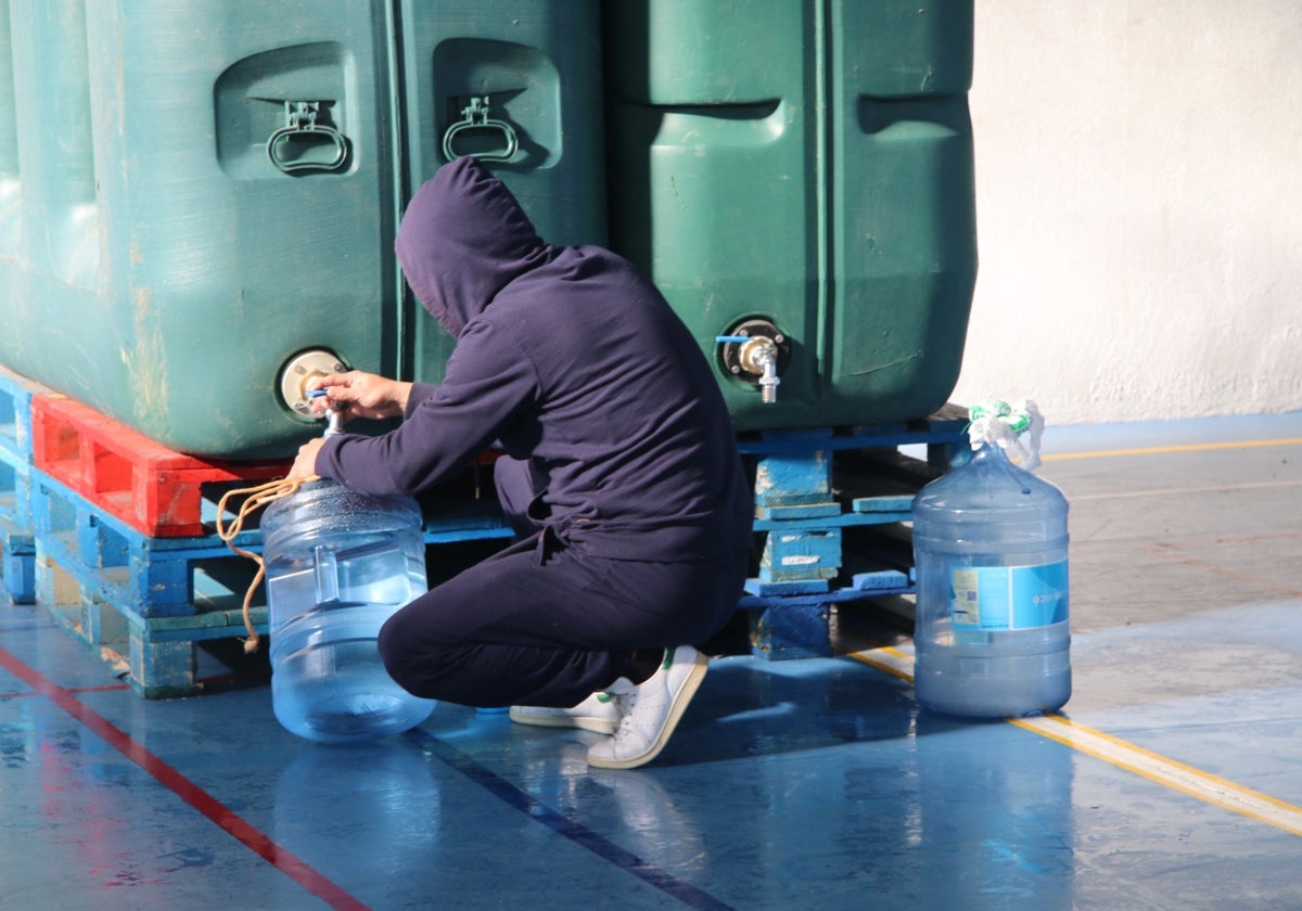 Un vecino llenado garrafas de agua en el frontón cubierto de Santa Marta de Tormes.