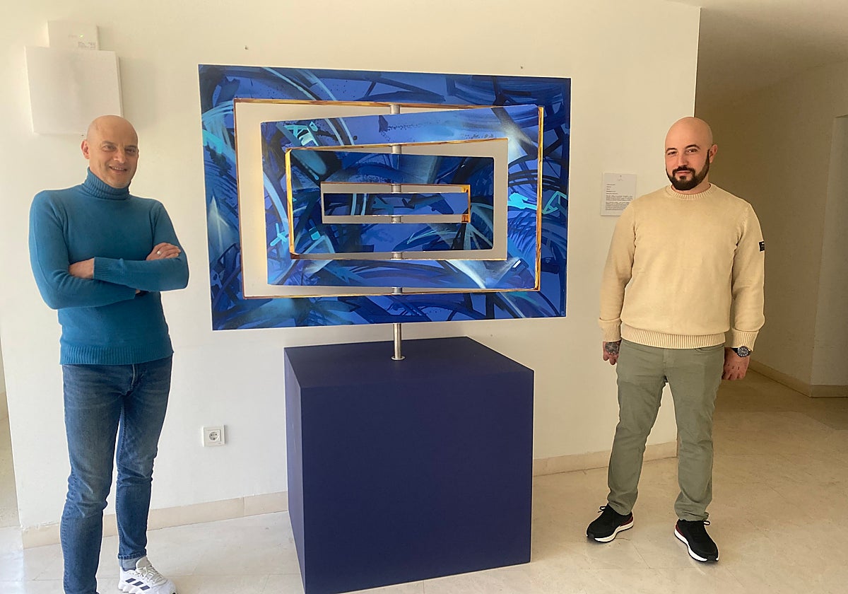 El edil Juan Carlos Bueno y el artista Daniel Martín, junto a la obra 'Eje'.