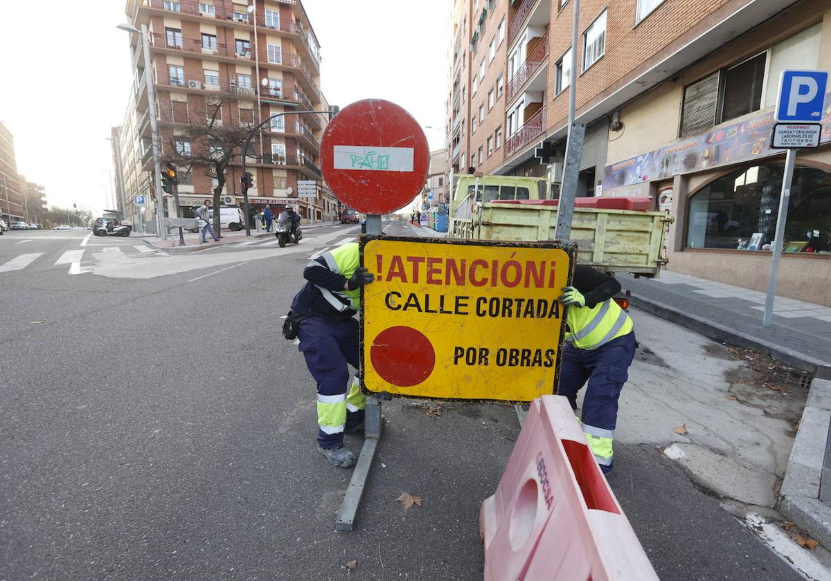 Los trabajadores de la empresa retiran el cartel que cortaba el paso.