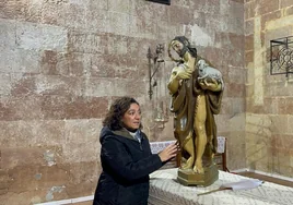 María Luisa López, restauradora, junto a la talla de San Juan Bautista.