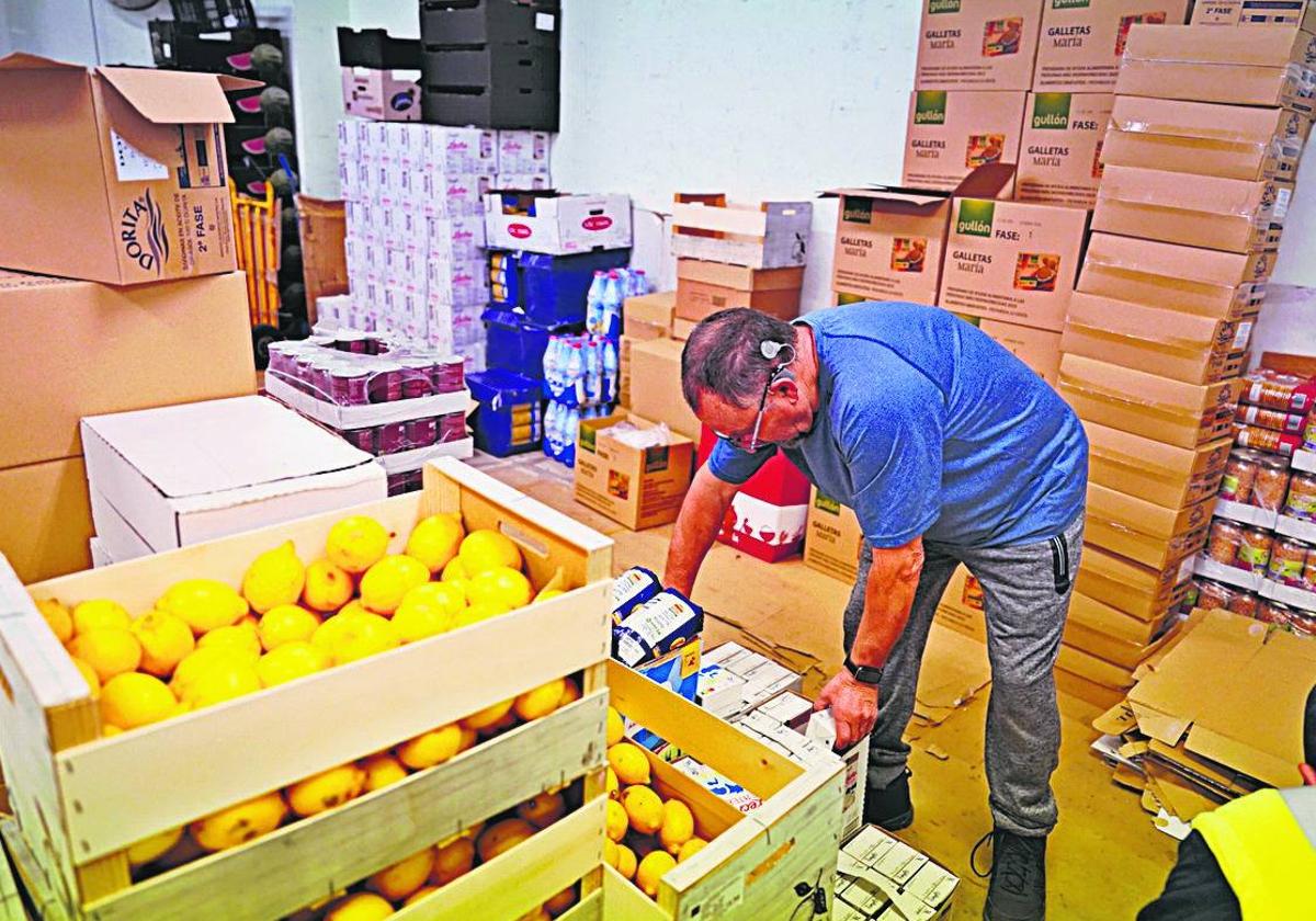 Reparto de fruta y entrega de alimentos en la Asociación de Amigos de la Hoguera de San Juan.