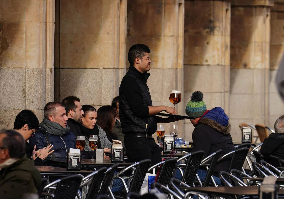 Un camarero atiende a los clientes de una terraza de la Plaza Mayor de Salamanca.