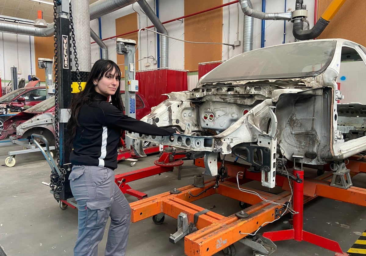 La estudiante Sara González con un vehículo en el taller de carrocería en el CIFP Río Tormes.