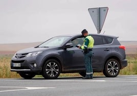 Un agente de la Guardia Civil parando a un turismo.