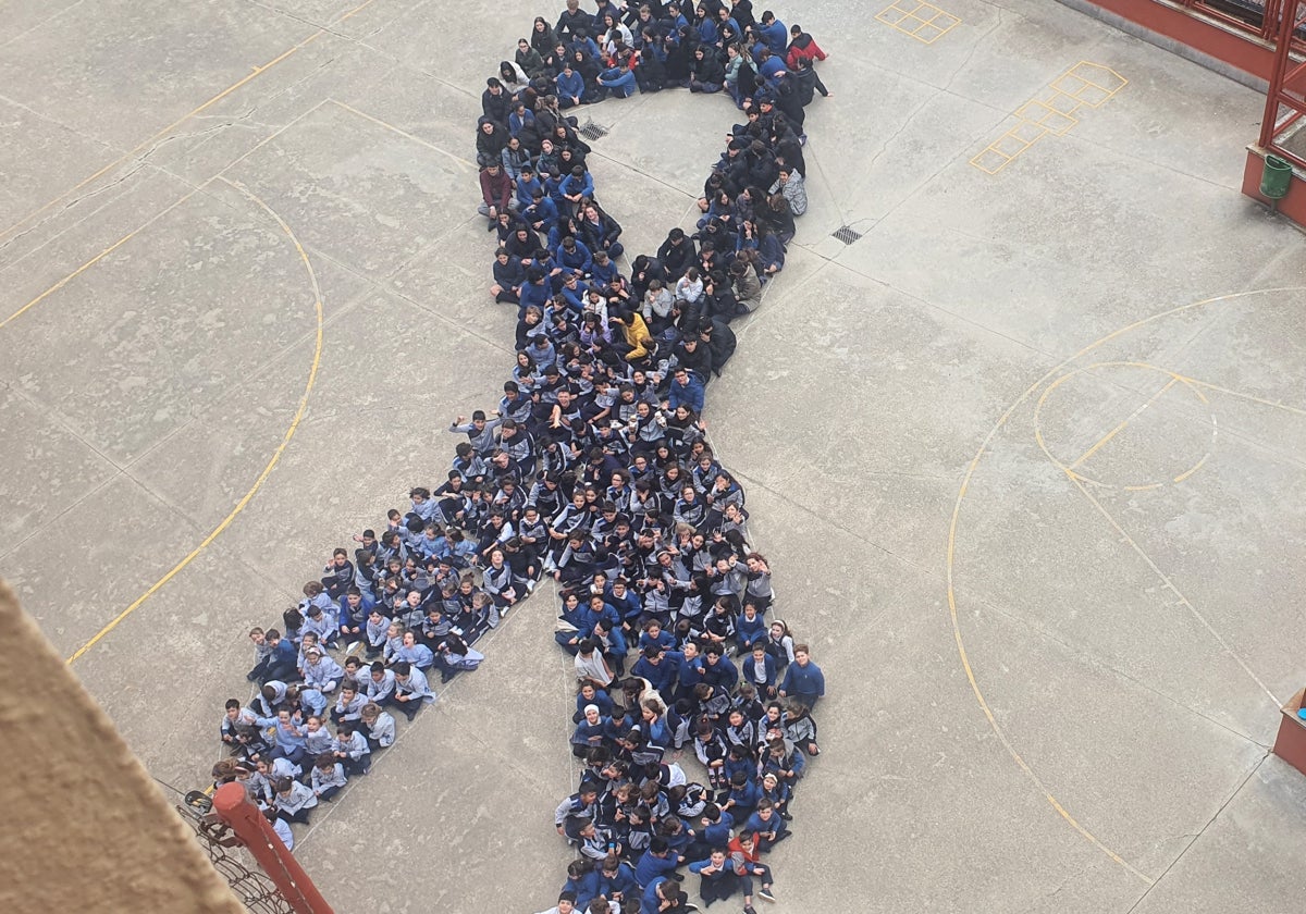 Imagen de los escolares del centro formando un gran lazo en el patio del colegio.