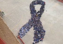 Imagen de los escolares del centro formando un gran lazo en el patio del colegio.