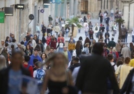 Decenas de personas caminando por el centro de la ciudad.