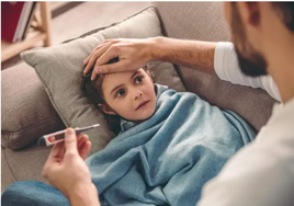 Un niño con fiebre en el sofá.