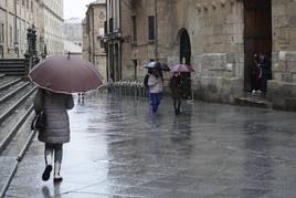 Viandantes resguardándose de la lluvia en la calle Compañía