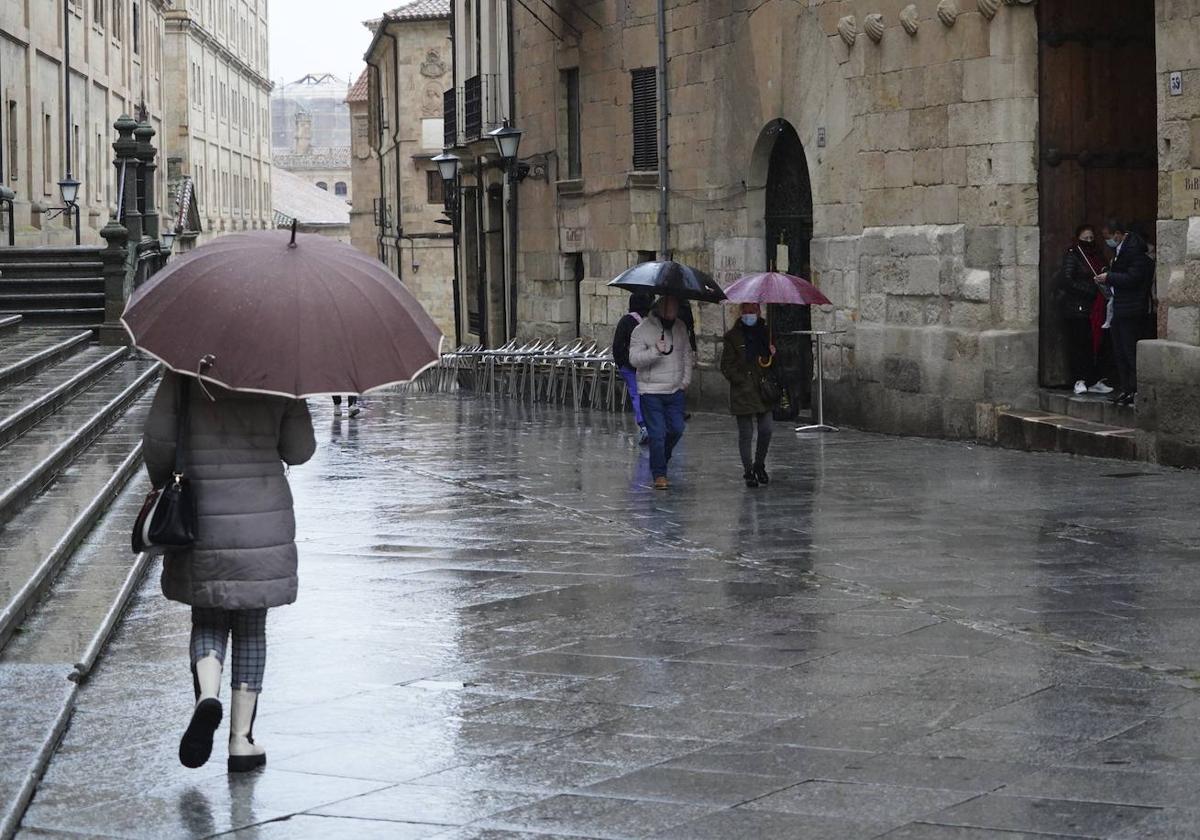 Viandantes resguardándose de la lluvia en la calle Compañía